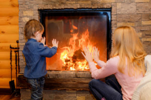 A woman and boy in front of a fireplace