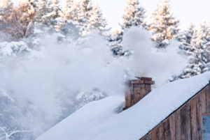 house with snow on roof and chimney