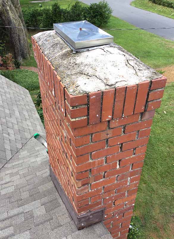 Masonry fireplace deteriorated mortar crown with cracks and tuckpointing repair needed.