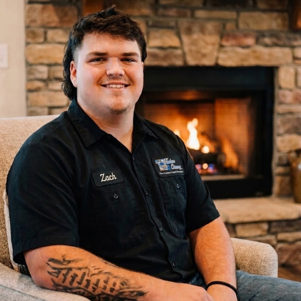 Zack, an employee from Hudson Chimney, sitting by a fireplace.